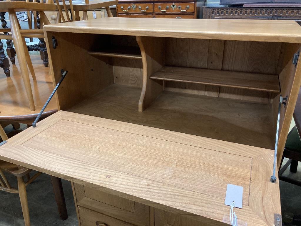 An Ercol elm fall front cabinet, width 82cm depth 44cm height 110cm